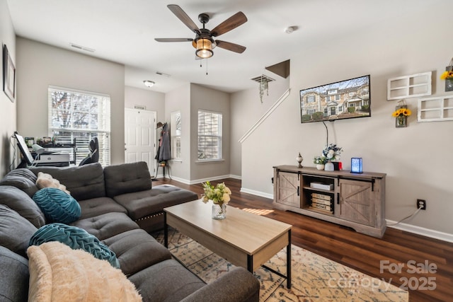 living room with visible vents, baseboards, wood finished floors, and a ceiling fan