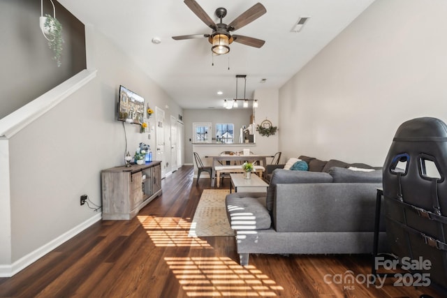 living area with visible vents, baseboards, ceiling fan, and wood finished floors