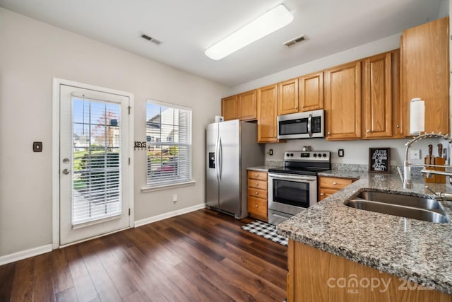 kitchen with light stone counters, visible vents, appliances with stainless steel finishes, and a sink