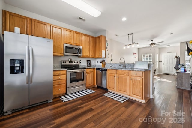 kitchen featuring visible vents, ceiling fan, appliances with stainless steel finishes, a peninsula, and a sink