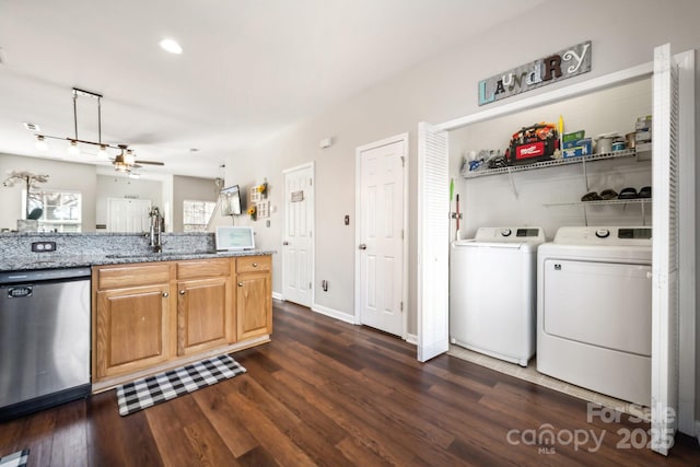 kitchen featuring light stone counters, dark wood-style floors, washing machine and clothes dryer, a sink, and dishwasher