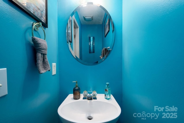 bathroom featuring a textured ceiling and a sink