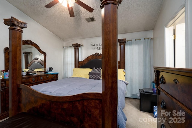 carpeted bedroom featuring lofted ceiling, decorative columns, visible vents, and a textured ceiling