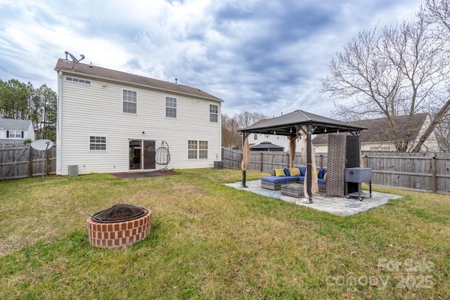 rear view of property featuring a gazebo, a patio area, an outdoor living space with a fire pit, and a fenced backyard