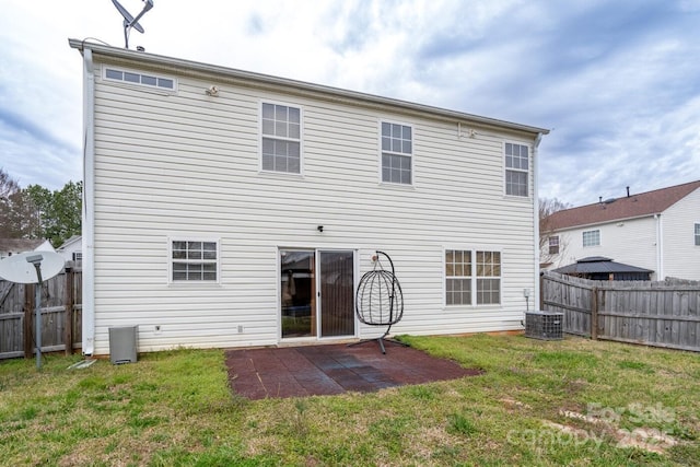 rear view of house with a patio area, central air condition unit, a lawn, and a fenced backyard