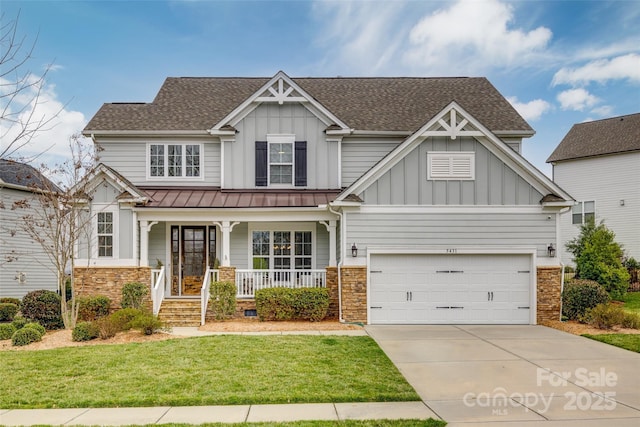 craftsman-style house featuring driveway, a front lawn, stone siding, board and batten siding, and covered porch