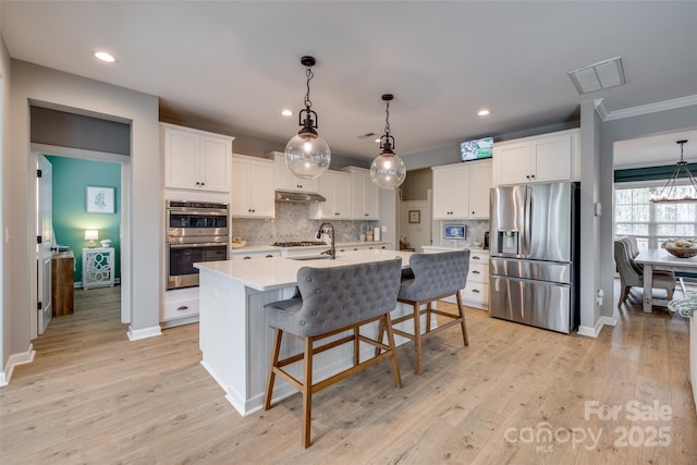 kitchen featuring stainless steel appliances, light wood-style floors, white cabinets, and light countertops