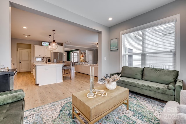 living area with recessed lighting, light wood-style flooring, and ceiling fan