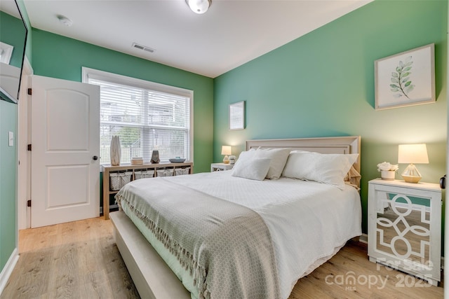 bedroom featuring visible vents and wood finished floors