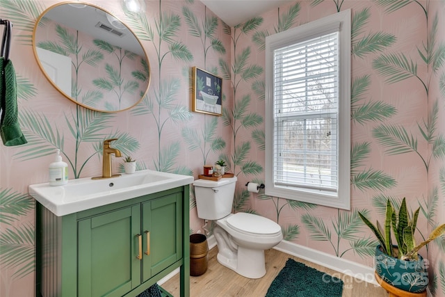 bathroom with visible vents, toilet, wallpapered walls, baseboards, and vanity