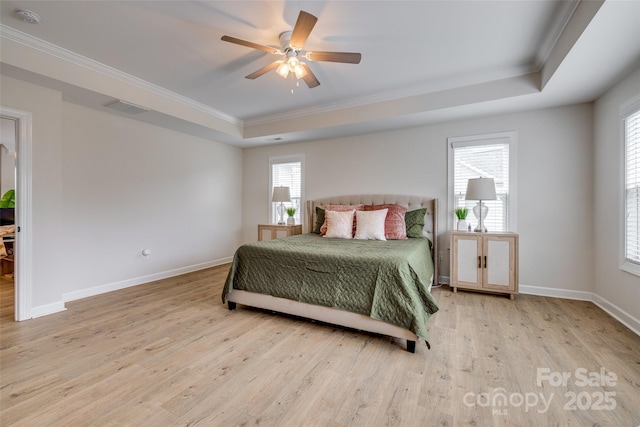 bedroom featuring visible vents, a raised ceiling, multiple windows, and wood finished floors