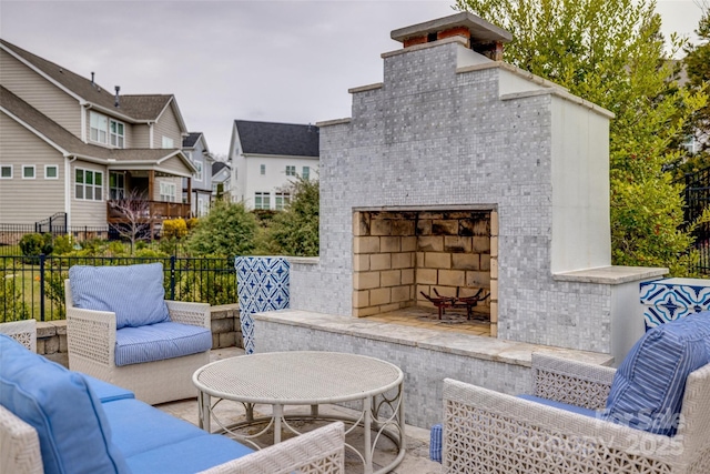 view of patio / terrace featuring an outdoor living space with a fireplace and fence