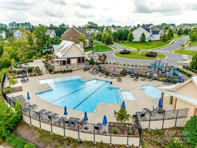 pool with a patio and fence