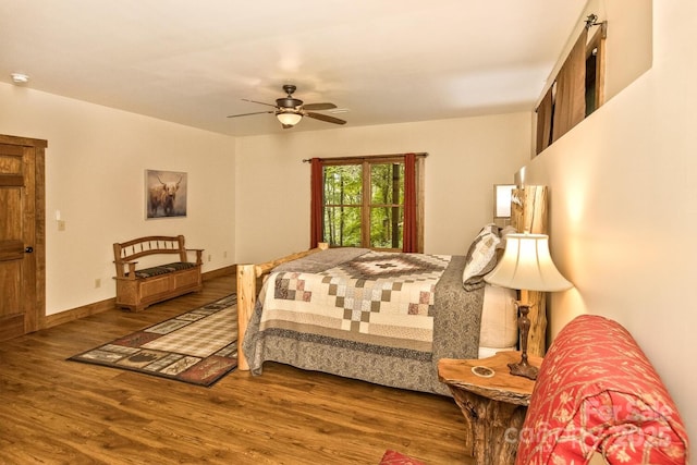 bedroom featuring a ceiling fan, baseboards, and wood finished floors