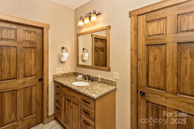 bathroom with vanity and a textured wall