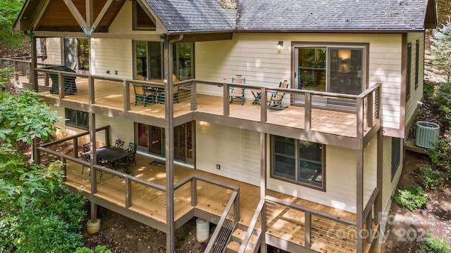 back of property with a deck, central AC, and a shingled roof