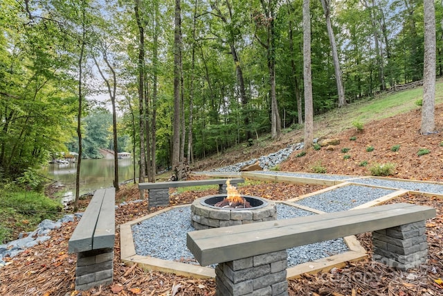 view of yard with a water view and an outdoor fire pit