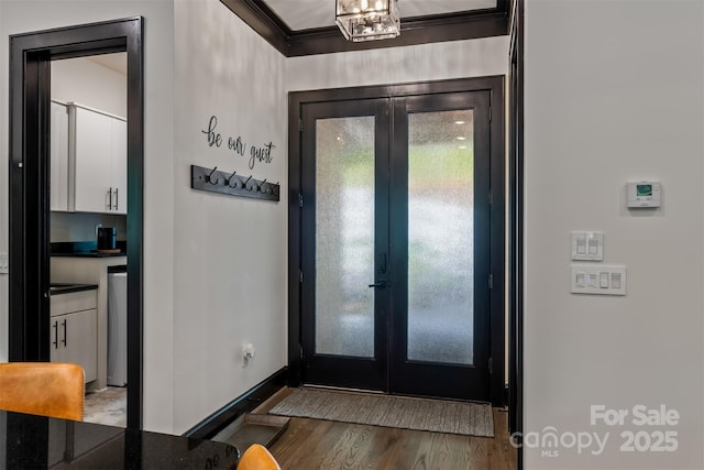 entryway with wood finished floors, french doors, baseboards, and ornamental molding