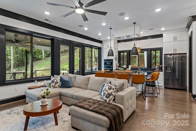 living area featuring recessed lighting, visible vents, wood finished floors, and french doors