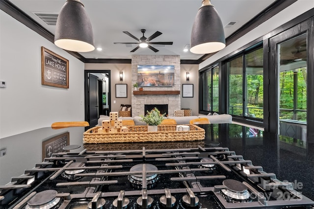 kitchen with cooktop, visible vents, a fireplace, and ornamental molding