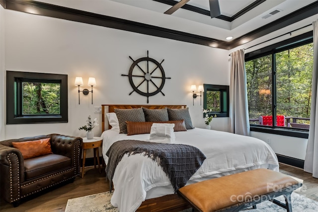 bedroom featuring visible vents, wood finished floors, and crown molding