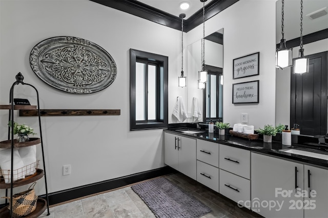 bathroom with double vanity, visible vents, baseboards, and a sink