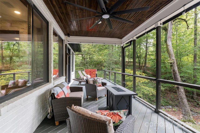 sunroom with wooden ceiling, plenty of natural light, and a ceiling fan