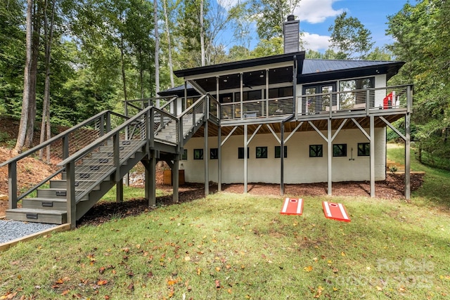 rear view of house featuring a deck, stairway, metal roof, and a chimney