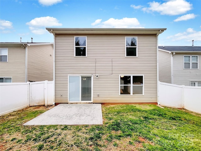 rear view of house featuring a patio, a lawn, and a fenced backyard