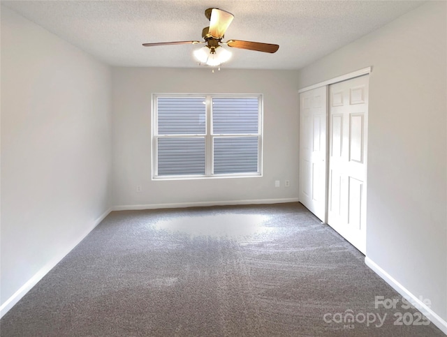 unfurnished bedroom with a closet, baseboards, a textured ceiling, and carpet floors