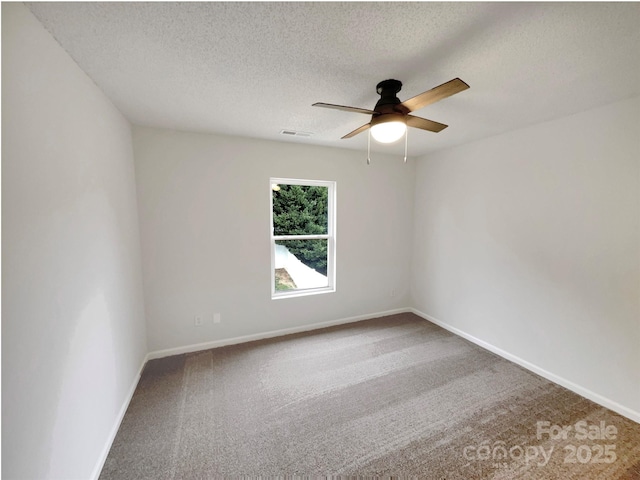 carpeted spare room featuring visible vents, baseboards, a textured ceiling, and a ceiling fan