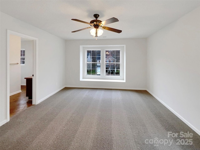 unfurnished room with baseboards, a ceiling fan, and carpet floors