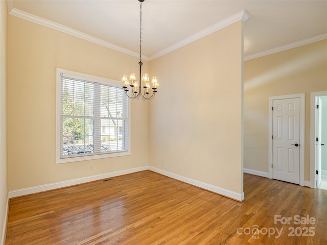 unfurnished room with visible vents, light wood-style flooring, baseboards, and ornamental molding