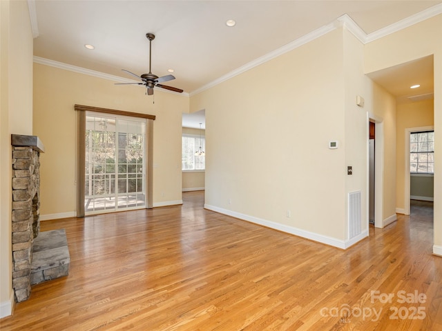 unfurnished living room with baseboards, visible vents, light wood finished floors, and ornamental molding