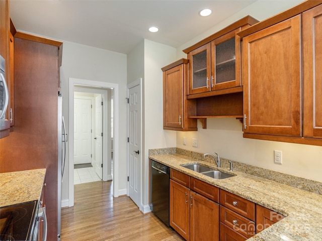 kitchen with light stone countertops, dishwasher, recessed lighting, light wood-style flooring, and a sink