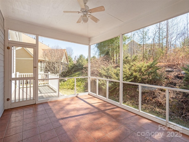 unfurnished sunroom featuring a ceiling fan