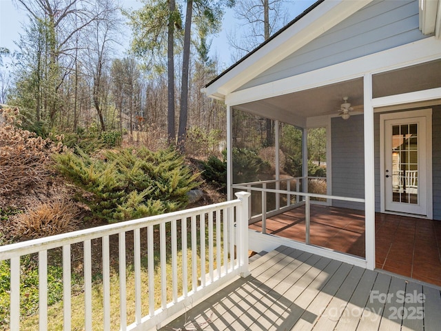 deck with a ceiling fan and a sunroom