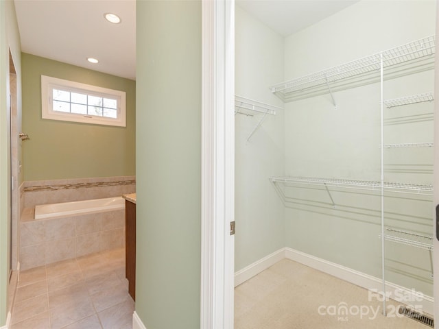 walk in closet with light tile patterned floors