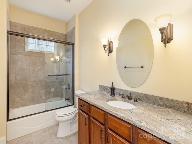 bathroom featuring vanity, tile patterned floors, toilet, and enclosed tub / shower combo