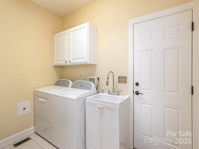 laundry area with visible vents, cabinet space, separate washer and dryer, light tile patterned floors, and baseboards