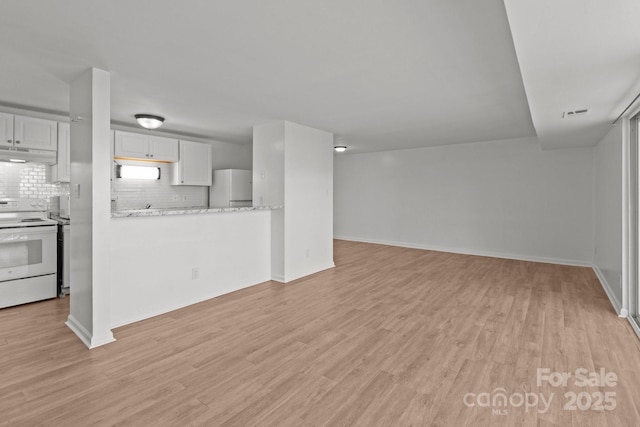 unfurnished living room featuring baseboards and light wood-style floors