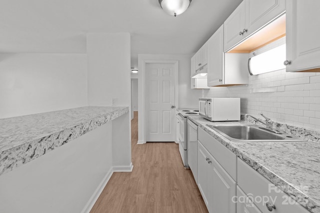 kitchen featuring a sink, under cabinet range hood, white cabinetry, white appliances, and light wood finished floors