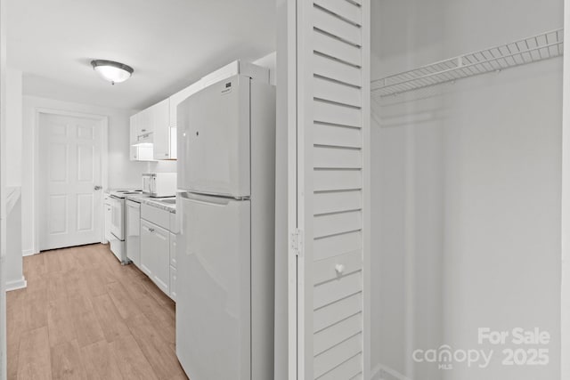 kitchen with white cabinetry, white appliances, light wood-style floors, and light countertops