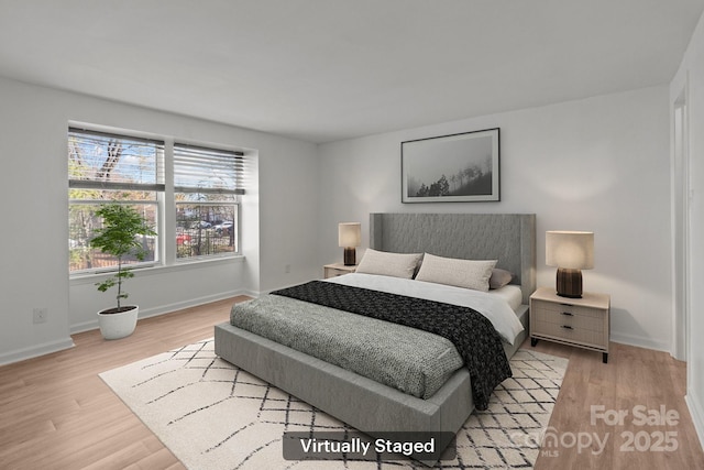 bedroom with light wood-type flooring and baseboards