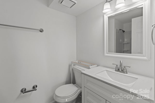 bathroom featuring vanity, toilet, a shower, and visible vents