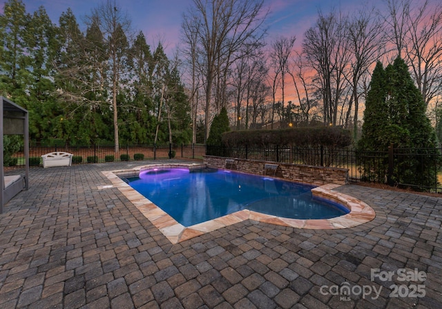 pool at dusk with a fenced in pool, a patio, and a fenced backyard