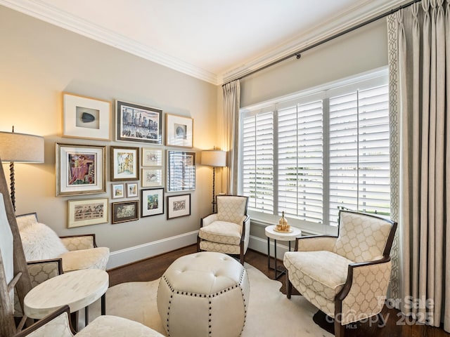 living area with baseboards, wood finished floors, and ornamental molding