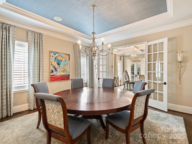 dining area with a healthy amount of sunlight, french doors, and a tray ceiling