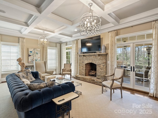 living area with beamed ceiling, a notable chandelier, a fireplace, and french doors