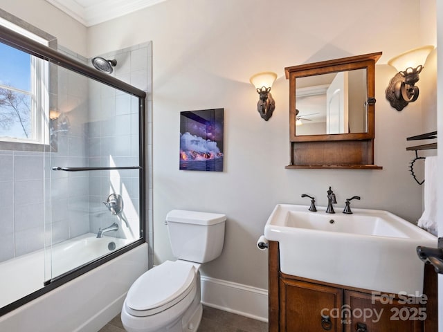 bathroom featuring baseboards, toilet, ornamental molding, combined bath / shower with glass door, and vanity